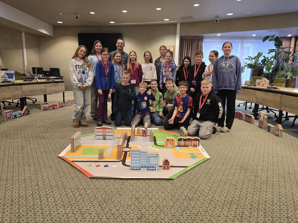 groep kinderen om het spelkleed Democracity een en de begeleiders van het spel