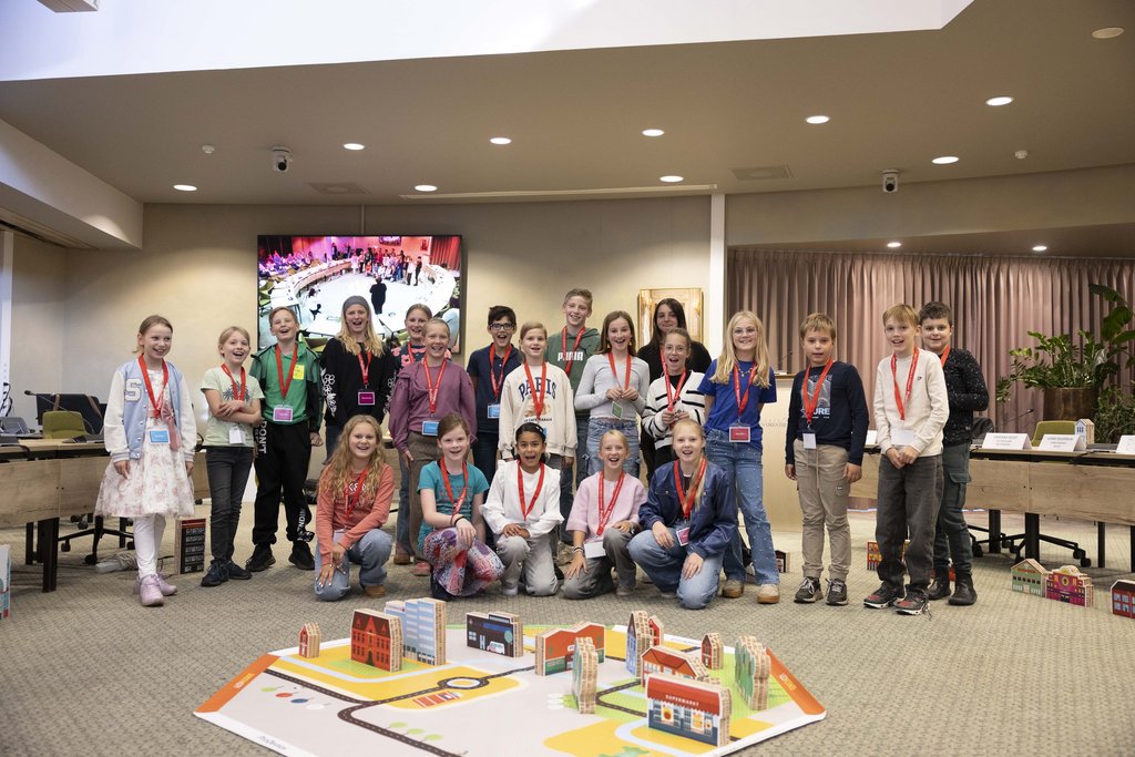 groep kinderen na afloop van het spel met op de voorgrond de door hen gebouwde gemeente