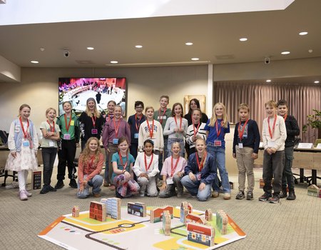 groep kinderen na afloop van het spel met op de voorgrond de door hen gebouwde gemeente